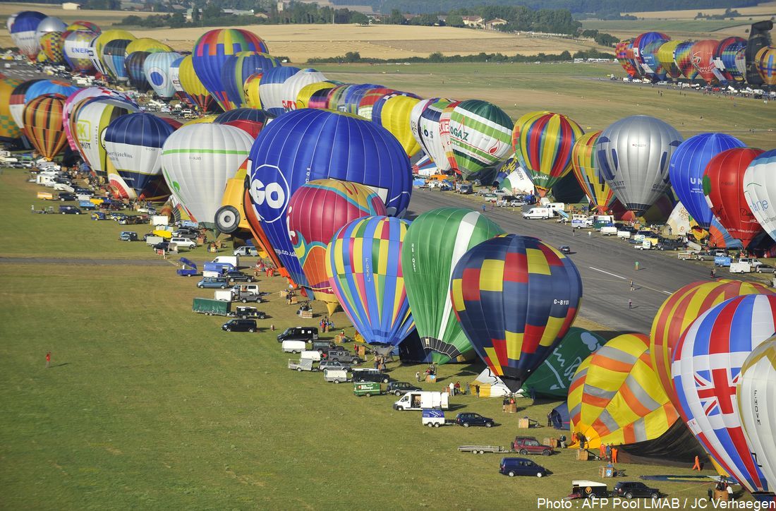 Hot-air balloons fly near Chambley-Bussieres airbase, eastern France, on July 26, 2015 , for the first day of the biennial "Lorraine Mondial Air Ballons", an international air-balloon meeting.  POOL AFP PHOTO / JEAN-CHRISTOPHE VERHAEGEN